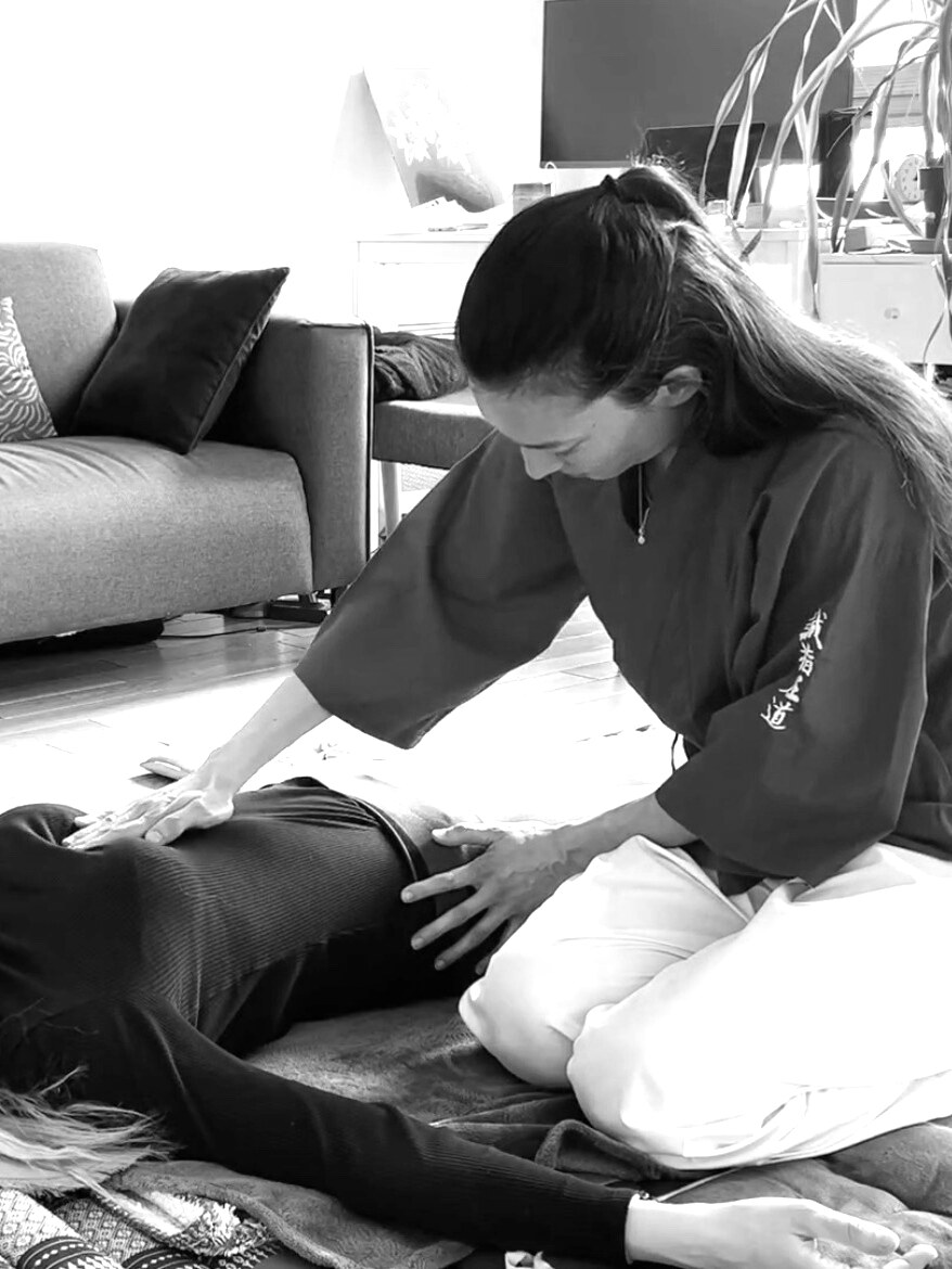 Adeline pratique le shiatsu en kimono rouge